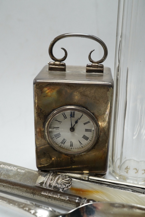 An Edwardian silver cased miniature carriage timepiece, by William Comyns, 67mm, London, 1901, together with a small quantity of assorted sterling or silver items, including flatware. Condition - poor to fair